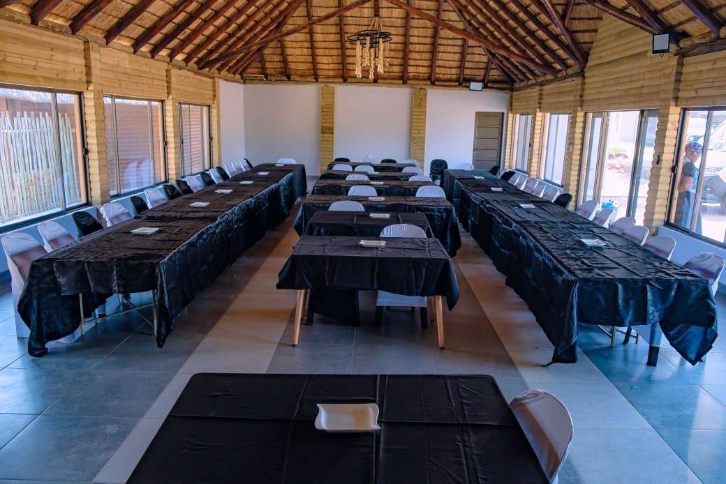 The thatched conference room set up with long tables